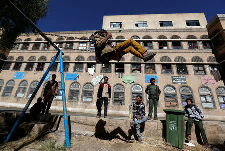 A boy plays on a swing as others watch in a yard of an orphanage in Sanaa, Yemen, January 2, 2017. REUTERS/Khaled Abdullah