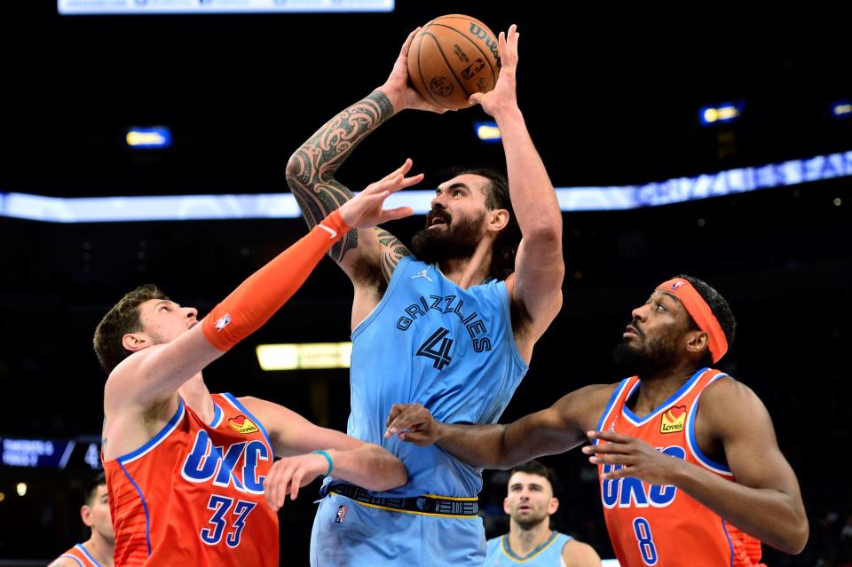 Memphis Grizzlies center Steven Adams (4) shoots between Oklahoma City Thunder center Mike Muscala (33) and guard Paul Watson (8) during the second half of an NBA basketball game Thursday, Dec. 2, 2021, in Memphis, Tenn. (AP Photo/Brandon Dill)