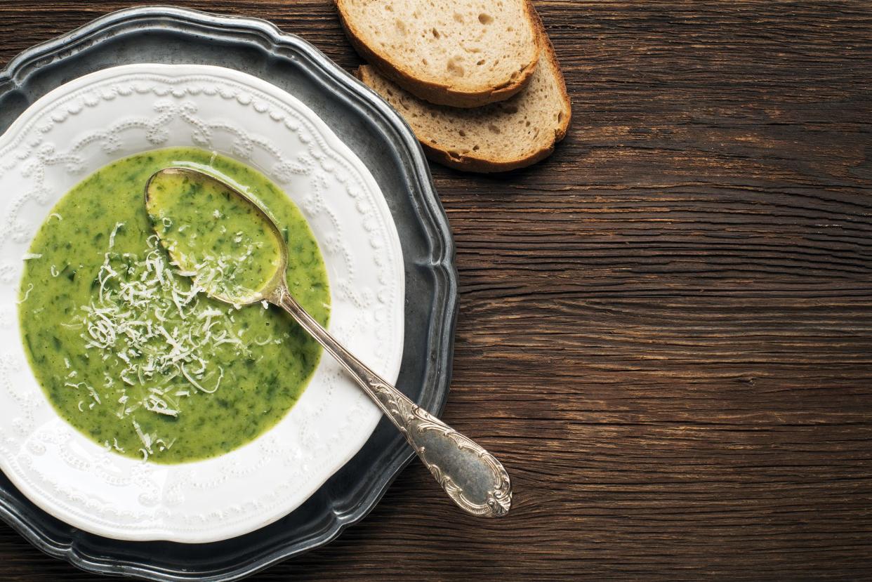 Fresh green soup on wooden background overhead shoot.