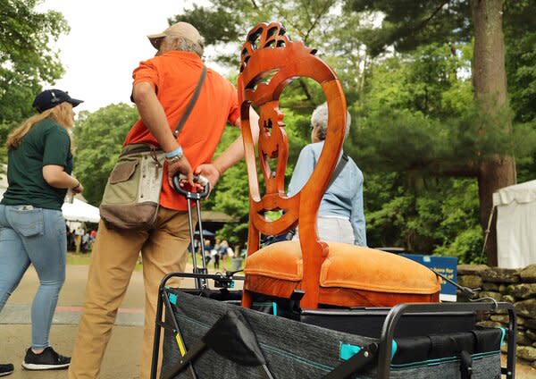 A man pulls an antique chair in a cart at Sturbridge Village for an episode of the <i>Roadshow</i>.