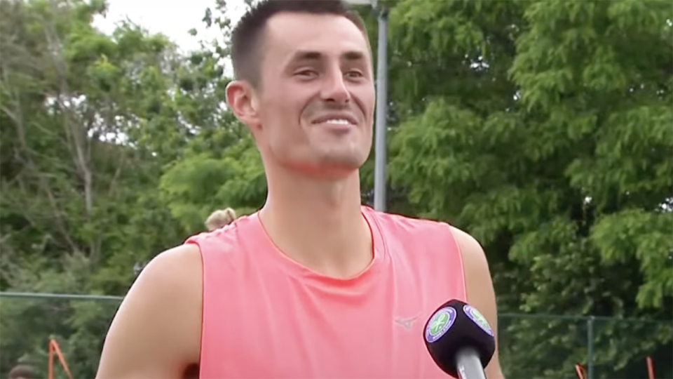 Bernard Tomic grins during an interview with John Inverdale at the Wimbledon qualifiers.