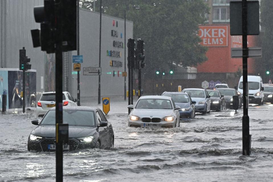 Cars drive through deep water on a flooded road in Nine Elms (Justin Tallis/AFP/Getty Images)