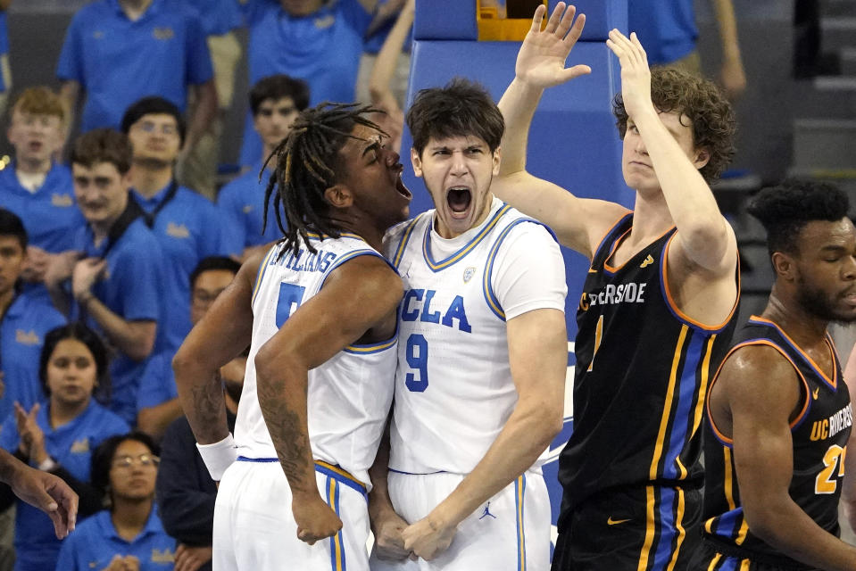 UCLA forward Berke Buyuktuncel, second from left, celebrates with guard Brandon Williams, left, after scoring and drawing a foul as UC Riverside center Benjamin Griscti, second from right looks on during the first half of an NCAA college basketball game Thursday, Nov. 30, 2023, in Los Angeles. (AP Photo/Mark J. Terrill)