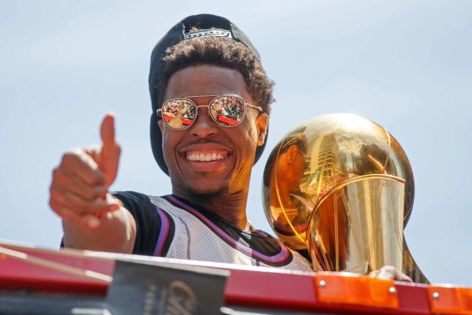 Kyle Lowry holds the Larry O'Brien Championship Trophy on the team bus during the Toronto Raptors Championship Victory Parade. (Photo by Mark Blinch/NBAE via Getty Images)