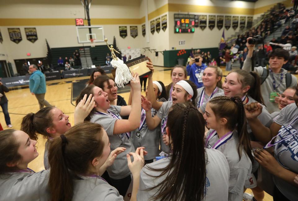 Canandaigua Academy girls basketball team celebrate with  their Section V Class A championship trophy after defeating Pittsford Sutherland at Rush Henrietta High School.  