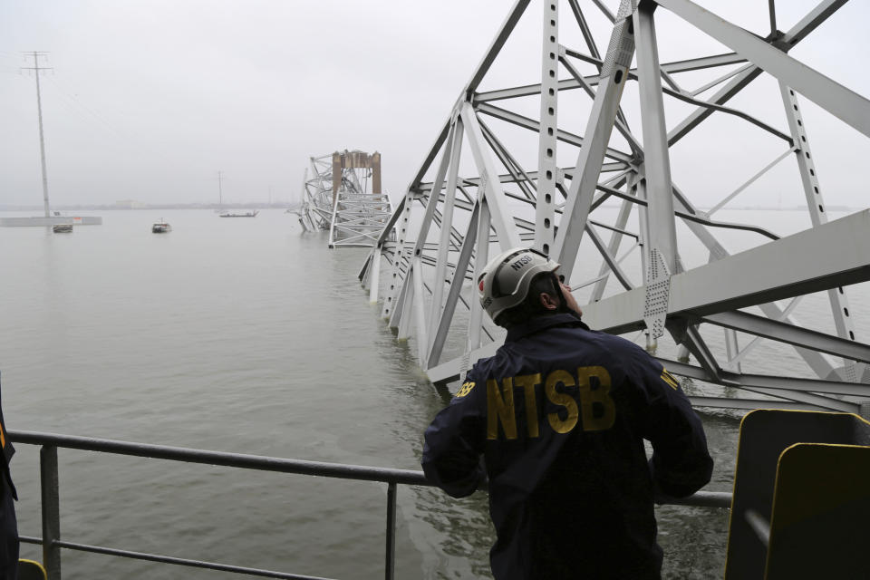 In this image released by the National Transportation and Safety Board, a NTSB investigator is seen on the cargo vessel Dali, which struck and collapsed the Francis Scott Key Bridge, Wednesday, March 27, 2024 in Baltimore. (Peter Knudson/NTSB via AP)