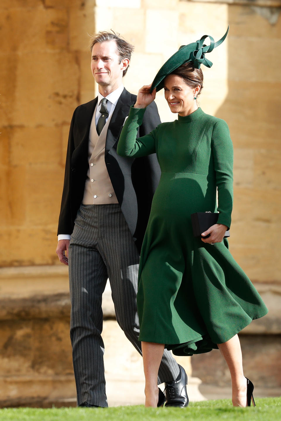 A pregnant Pippa Middleton keeps a firm grip on her hat. (Photo: Getty Images)