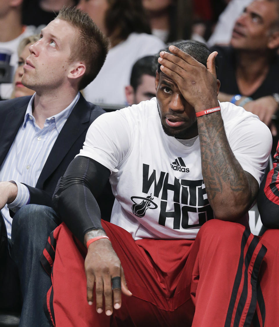 Miami Heat forward LeBron James (6) adjusts his headband while watching from the bench in the fourth quarter against the Brooklyn Nets during Game 3 of an Eastern Conference semifinal NBA playoff basketball game, Saturday, May 10, 2014, in New York. The Nets won 104-90. (AP Photo/Julie Jacobson)