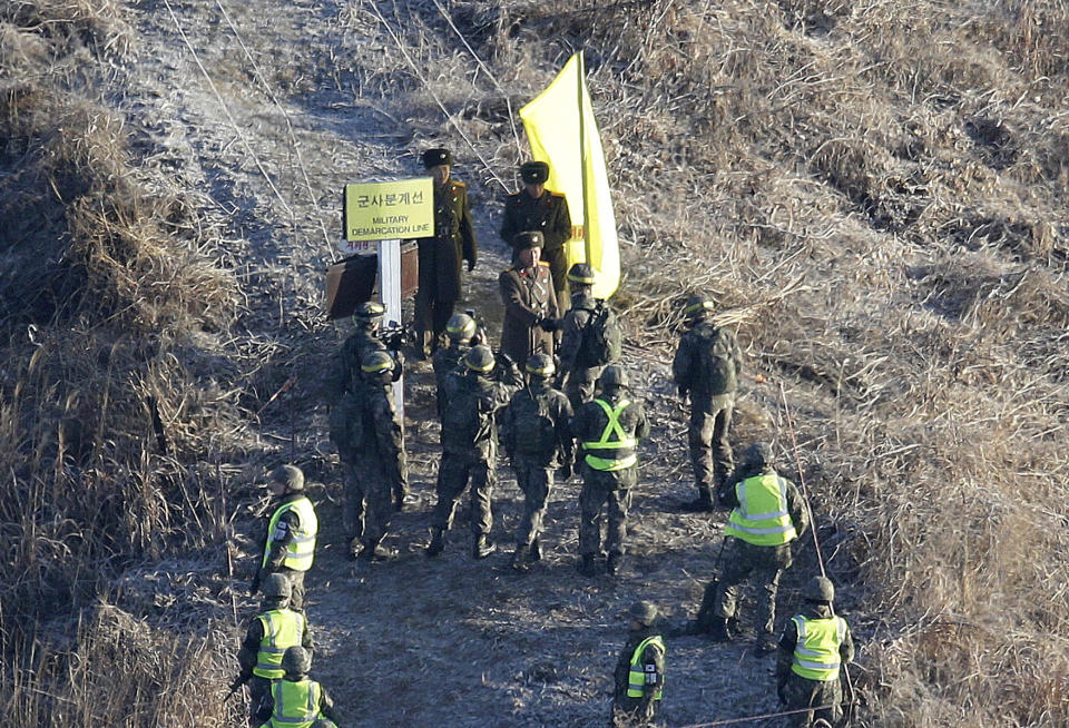 A South Korean army soldier, center bottom, shakes hands with a North Korean army soldier before crossing the Military Demarcation Line inside the Demilitarized Zone (DMZ) to inspect the dismantled North Korean guard post in the central section of the inter-Korean border in Cheorwon, Wednesday, Dec. 12, 2018. South Korea and North Korea have removed some of their guard posts along the border as part of their military agreement last September. (AP Photo/Ahn Young-joon, Pool)