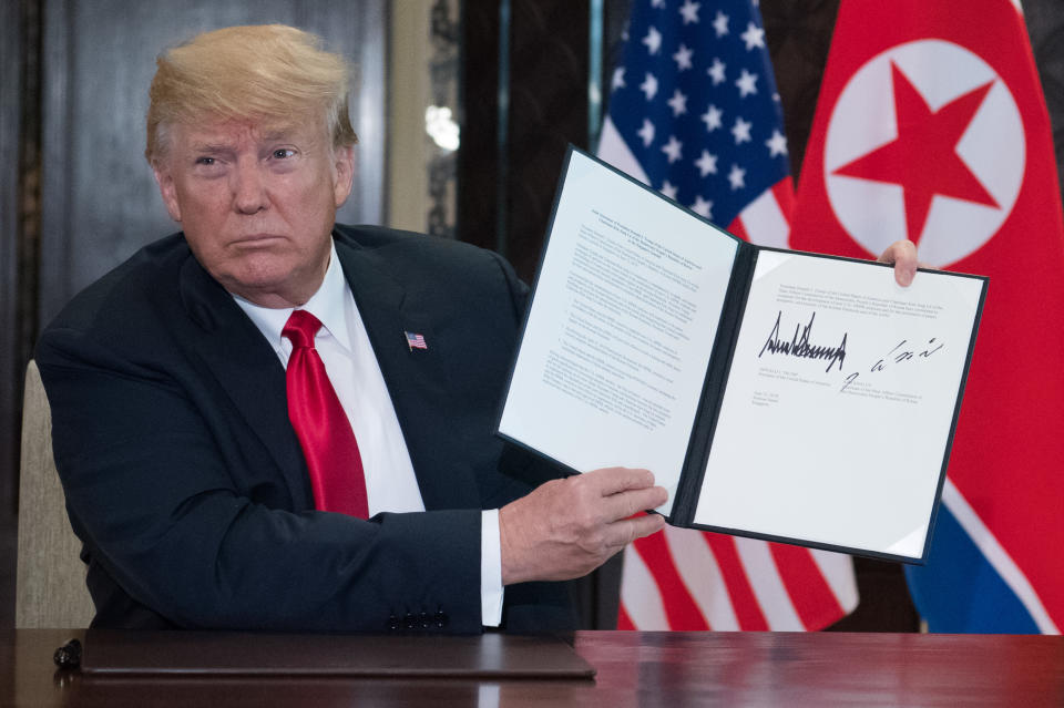 <p>President Donald Trump holds up a document signed by him and North Korea’s leader Kim Jong Un following a signing ceremony during their historic US-North Korea summit, at the Capella Hotel on Sentosa island in Singapore on June 12, 2018. (Photo: Saul Loeb/AFP/Getty Images) </p>