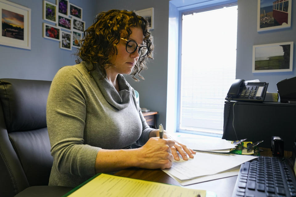 Dr. Katie McHugh, an obstetrician-gynecologist, looks over abortion content forms as she works at the Women's Med Center in Indianapolis, Friday, Sept. 23, 2022. Indiana abortion clinics began seeing patients again on Friday after an Indiana judge blocked the state's abortion ban from being enforced. The State has appealed the order. (AP Photo/Michael Conroy)