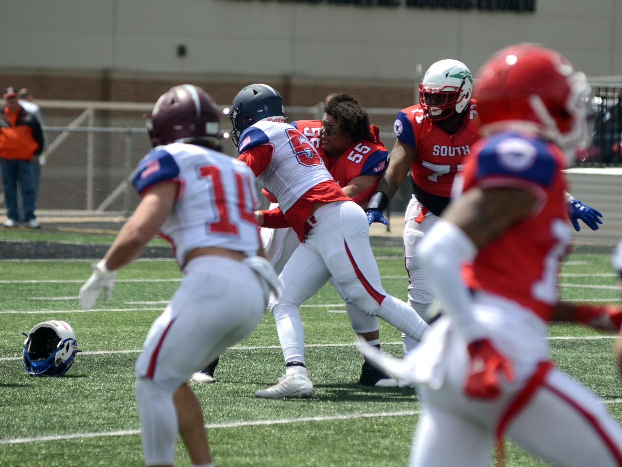 Zanesville's Julian Jackson, of the South squad, loses his helmet while making a block during a 39-18 loss to the North during the annual Ohio North-South All-Star Football Classic on Saturday at Paul Brown Tiger Stadium in Massillon.