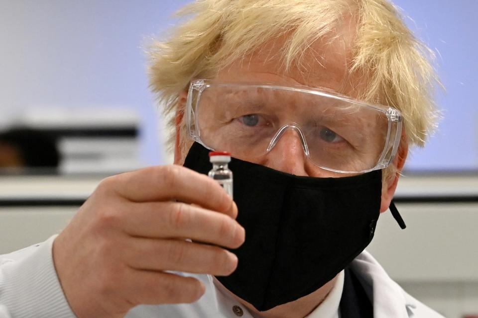 <p>Boris Johnson examins a coronavirus vaccine being made in Wrexham</p> (REUTERS)