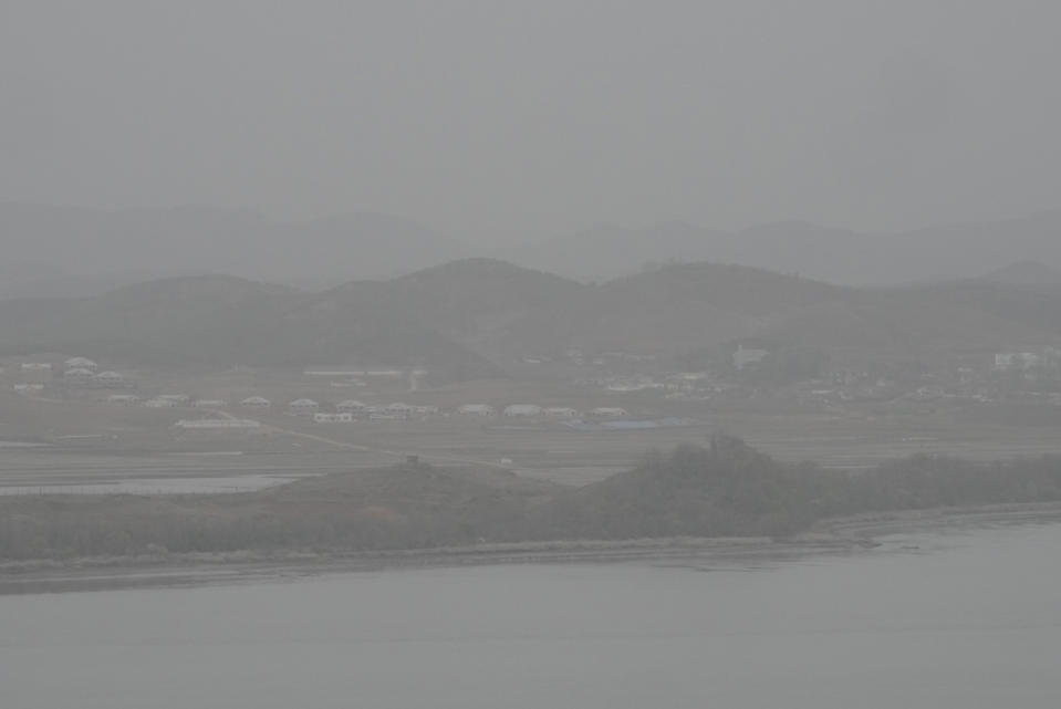 The field of North Korea's Kaepoong town covered with a thick haze of fine dust particles is seen from the Unification Observation Post in Paju, South Korea, near the border with North Korea, Thursday, April 13, 2023. North Korea on Thursday conducted its first intercontinental ballistic missile launch in a month, possibly testing a new type of more mobile, harder-to-detect weapons system, its neighbors said, in an extension of the North's provocative run of missile tests. (AP Photo/Ahn Young-joon)