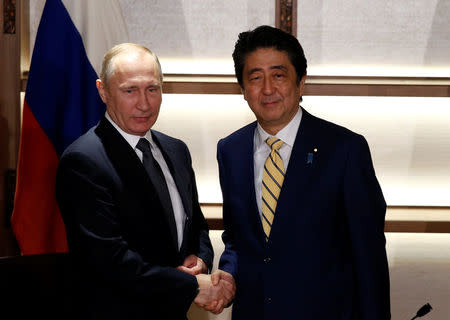 Russia's President Vladimir Putin (L) shakes hands with Japan's Prime Minister Shinzo Abe at the start of their summit meeting in Nagato, Yamaguchi prefecture, Japan, December 15, 2016. REUTERS/Toru Hanai