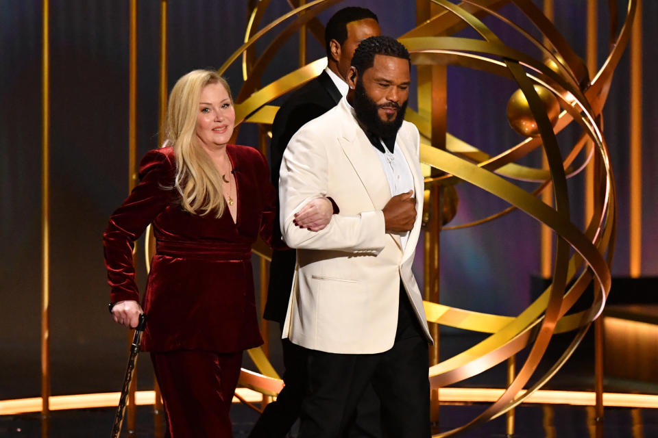 christina walking on stage holding anthony anderson's arm