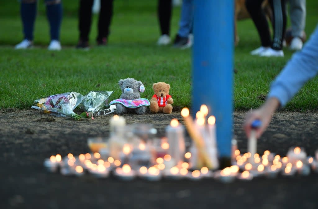 Flowers, soft toys and candles are seen at a vigil at the scene (Anthony Delvin/PA) (PA Wire)