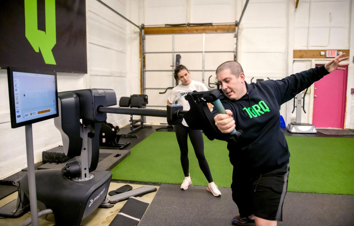 Kyle Piraino, owner of Torq Fitness & Performance, shows Washington volleyball player Aubrey Hurckes the proper form for a test on a Proteus machine during a training session at his facility at 109 Harvey Court in East Peoria. The Proteus is a state-of-the-art motion testing machine for measuring power and performance.