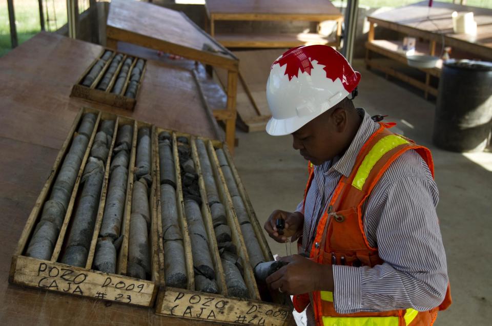 In this April 10, 2012 photo, geologist Francisque Pierre examines samples of stone to be examined for minerals and metals at an exploratory mine run by the SOMINE mining company in the department of Trou Du Nord, Haiti. Haiti's land may yet hold the solution to centuries of poverty: there is gold hidden in its hills, and silver and copper too. Now, two mining companies are drilling around the clock to determine how to get those metals out, and how much it might cost. (AP Photo/Dieu Nalio Chery)