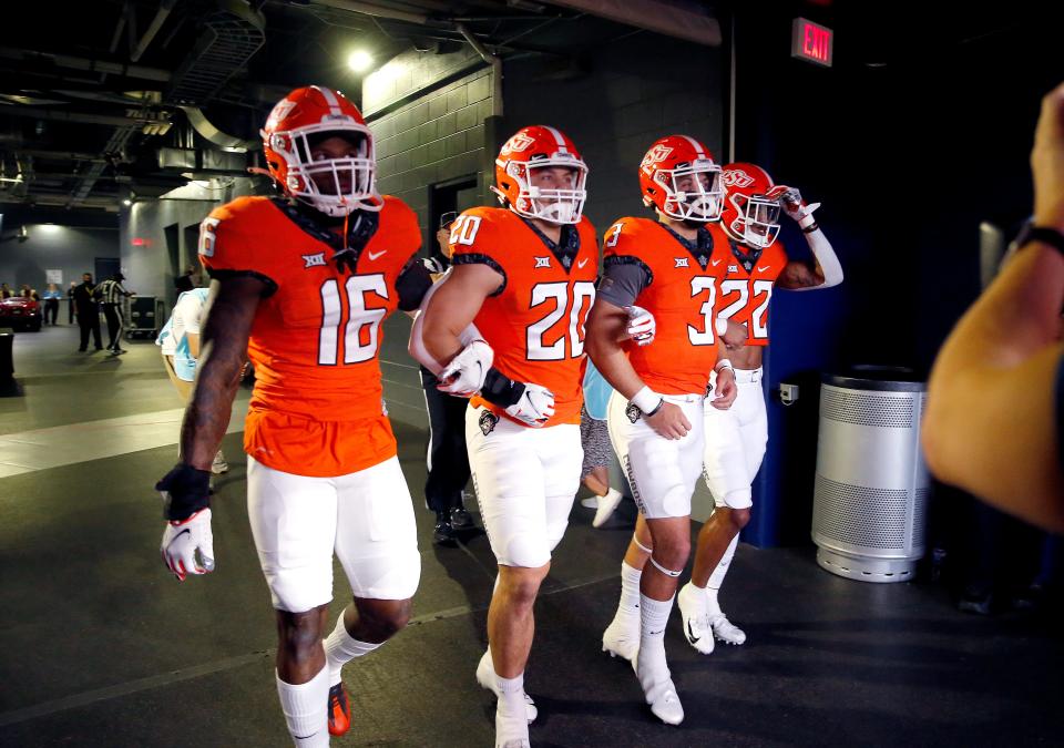 Oklahoma State's Demarco Jones (22), Spencer Sanders (3), Malcolm Rodriguez (20) and Devin Harper walk onto the field before the Big 12 Football Championship Game between the Oklahoma State Cowboys and the Baylor Bears at AT&T Stadium in Arlington, Texas,  Saturday, Dec. 4, 2021. 