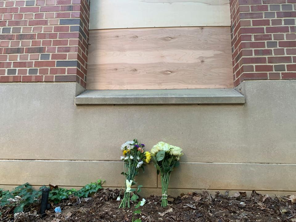 Flowers lay under a boarded up window at Caudill Labs on the UNC-Chapel Hill campus in Chapel Hill, N.C., Tuesday, Aug. 29, 2023, after a graduate student fatally shot his faculty adviser.