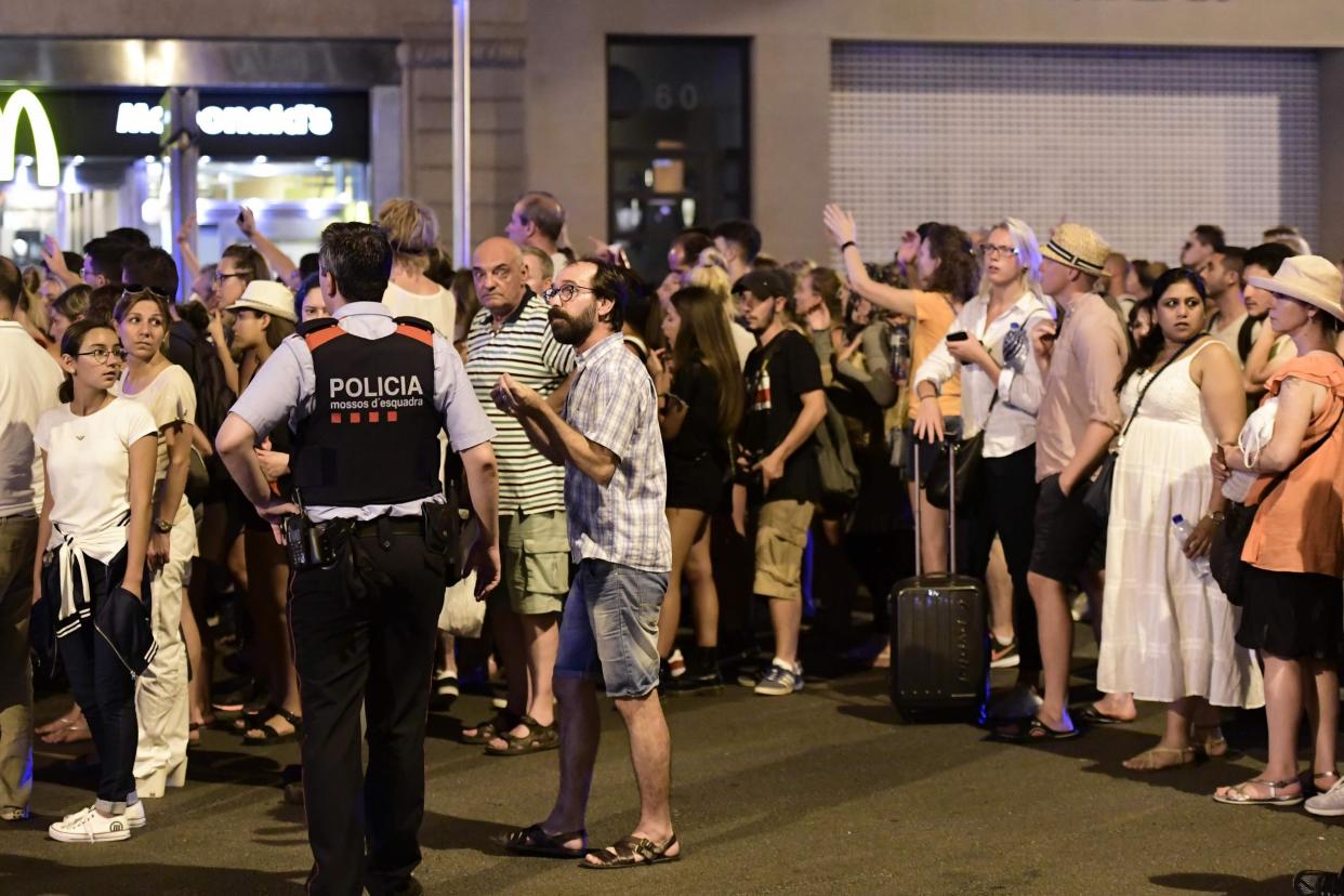 Tourists wait for the police to allow them to come back to their hotel on the Rambla boulevard: AFP/Getty