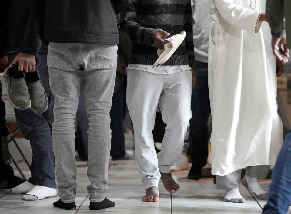 People retrieve their shoes after attending a Dec. 8 prayer service at Abubakar Assidiq Islamic Center.