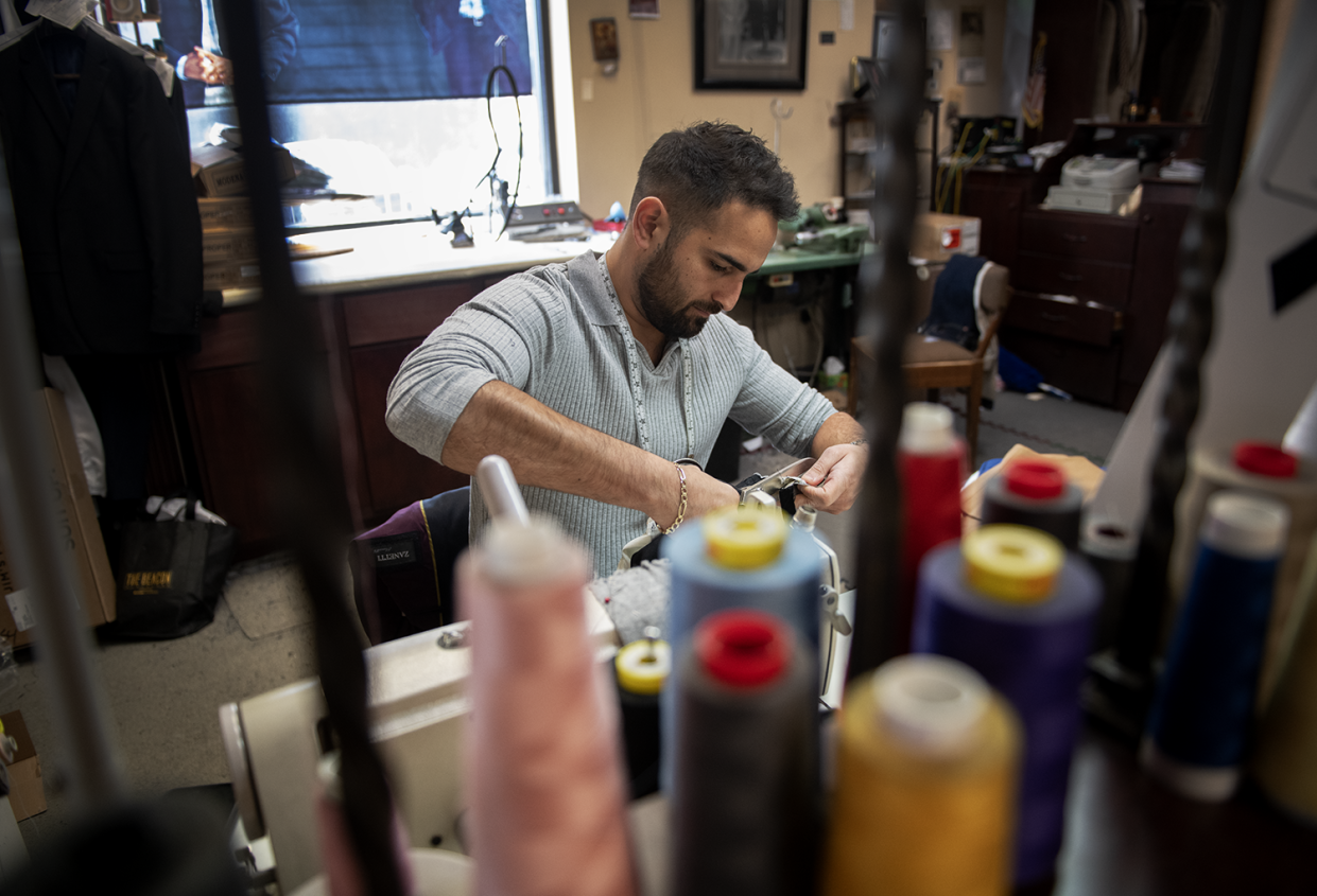 George Jabbour, the owner of Jabbour's Clothing & Tailoring in Stow, works on a pair of pants. He says he was stunned when Joann Inc. recently filed for bankruptcy.