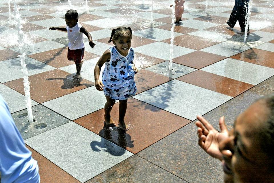 PARKER ESHELMAN/ The Kansas City Star Destiny, left, and Grace Johnson play in the Crown Center fountains, as their mom, Natisha gets a good laugh. cutline: Destiny (left) and Grace Johnson played in the fountains at Crown Center on a recent Sunday afternoon. Parker Eshelman/The Kansas City Star