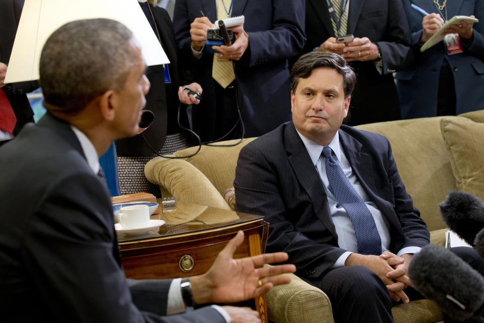 FILE- In this Oct. 22, 2014, file photo, reporters take notes as Ebola coordinator Ron Klain listens to President Barack Obama speak to the media about the government's Ebola response in the Oval Office of the White House in Washington. New federal Ebola response squads are being readied to rus to an U.S. city where a new Ebola case might be identified, officials said. Klain is preparing to serve as President-elect Joe Biden’s chief of staff, a job often referred to as the nation’s chief operating officer. (AP Photo/Jacquelyn Martin, File)