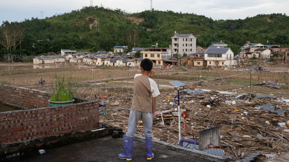 A child looks at flooded fields following heavy rainfall in Meizhou, Guangdong province on June 23, 2024. - John Ricky/Anadolu/Getty Images