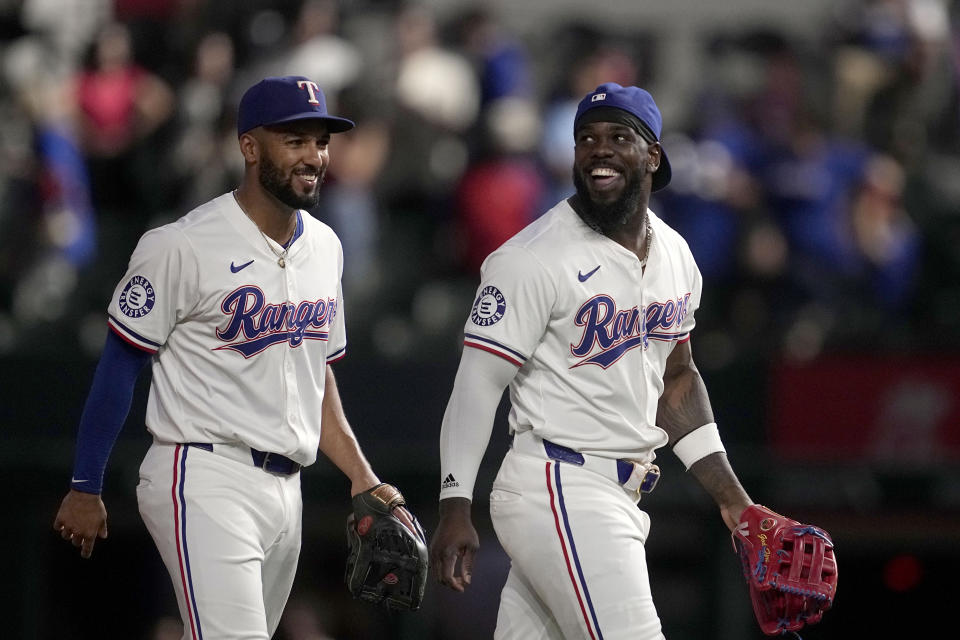 Texas Rangers' Marcus Semien, left, and Adolis Garcia walk off the field after their team's win against the Toronto Blue Jays in a baseball game in Arlington, Texas, Wednesday, Sept. 18, 2024. (AP Photo/Tony Gutierrez)