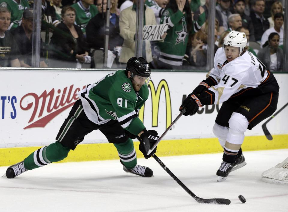 Dallas Stars' Tyler Seguin (91) attempts a wrap-around shot at the net as Anaheim Ducks' Hampus Lindholm (47) defends during the third period of Game 4 of a first-round NHL hockey Stanley Cup playoff series, Wednesday, April 23, 2014, in Dallas. The Stars won 4-2. (AP Photo/Tony Gutierrez)