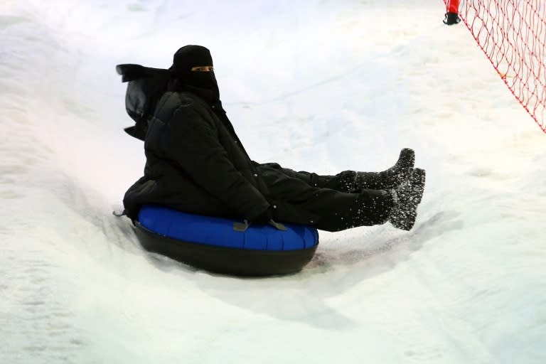 A Saudi woman slides on snow at "Snow City" in Riyadh