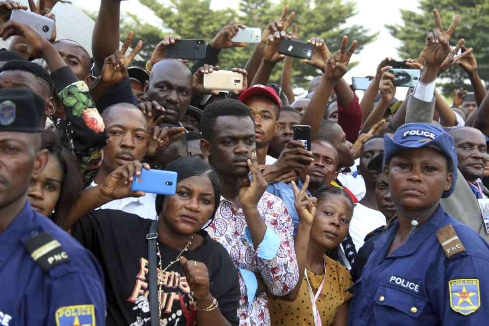 FILE - In this June 1 2019 file photo shot by AP contributing photographer John Bompengo, people gather to watch as the coffin carrying the remains of longtime Congolese opposition leader Etienne Tshisekedi is carried to Kinshasa's Martyrs Stadium for his funeral ceremony in Kinshasa, Democratic Republic of Congo. Relatives say longtime Associated Press contributor John Bompengo has died of COVID-19 in Congo's capital. Bompengo, who had covered his country's political turmoil over the course of 16 years, died Saturday, June 20, 2020 at a Kinshasa hospital. (AP Photo/John Bompengo, file)