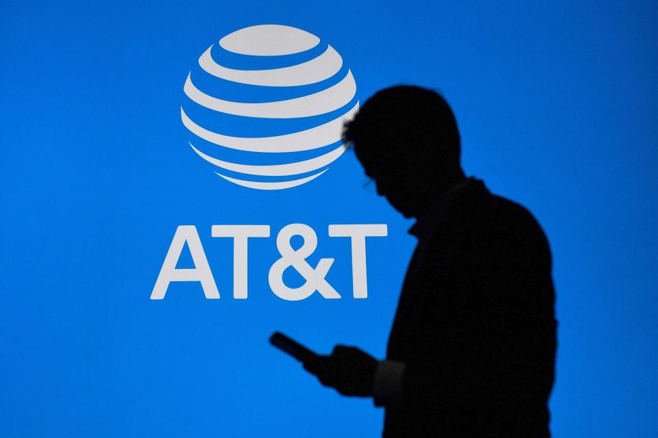 A visitor walks past US multinational telecommunications AT&T logo at the Mobile World Congress in 2023.