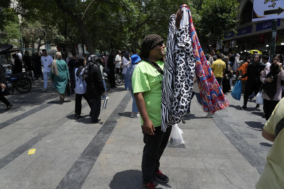 A vendor advertises women's cloths in the old main bazaar of Tehran, Iran, Thursday, June 13, 2024. The rise of the “Hamster Kombat” app in Iran highlights a harsher truth facing the Islamic Republic's economy ahead of its presidential election this week to replace the late President Ebrahim Raisi, who died in a helicopter crash in May. (AP Photo/Vahid Salemi)