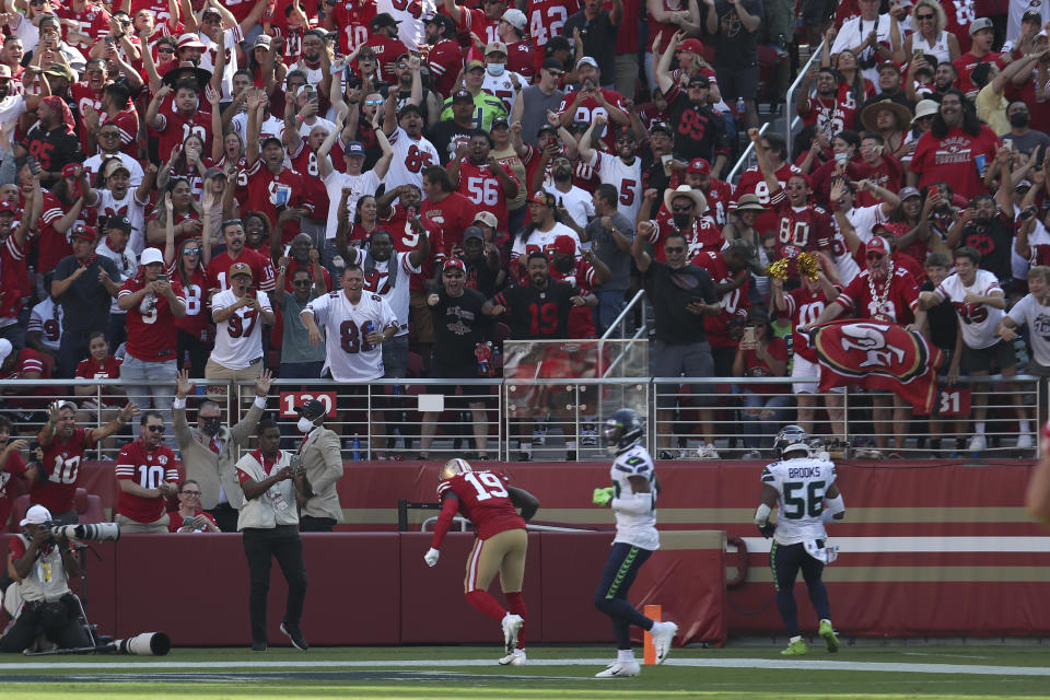 Fans cheer as San Francisco 49ers wide receiver Deebo Samuel (19) scores against the Seattle Seahawks during the second half of an NFL football game in Santa Clara, Calif., Sunday, Oct. 3, 2021. (AP Photo/Jed Jacobsohn)