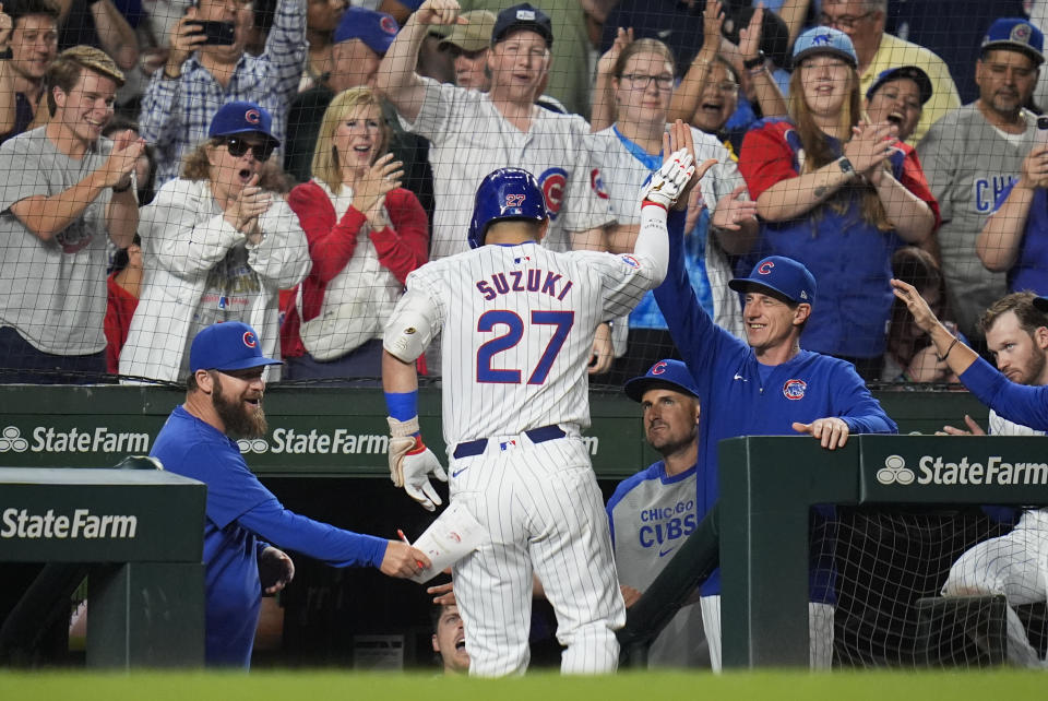 Chicago Cubs designated hitter Seiya Suzuki, center, high-fives manager Craig Counsell after hitting a two-run home run during the third inning of a baseball game against the Washington Nationals, Thursday, Sept. 19, 2024, in Chicago. (AP Photo/Erin Hooley)