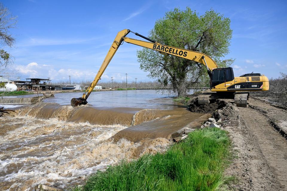 Crews work unclog the Tule River Friday, March 17, 2023 at Road 192 just north of Avenue 168 and east of Woodville. Road closures are common in south Tulare County. Flood warnings have been issued for many areas.