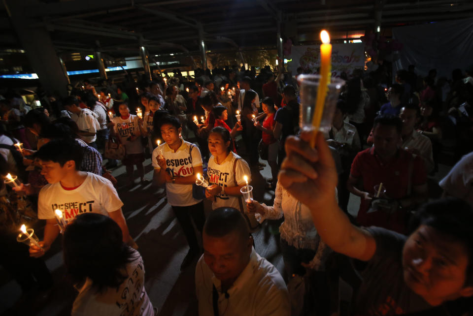 Members of Thailand's "White Shirt" movement are seen during a candlelight vigil to demand democratic elections and political reforms in Bangkok, Thailand, Friday, Jan. 31, 2014. Thailand's general election is scheduled for Sunday, Feb. 2, 2014, but the main opposition Democrat Party is boycotting it, and its supporters seeking to scuttle it by blocking access to polling stations throughout Bangkok. (AP Photo/Wally Santana)