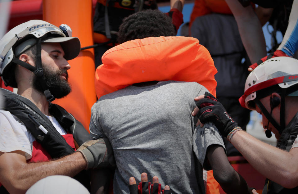 In this photo taken Saturday and released Sunday, Aug. 11, 2019, a rescue team of the Ocean Viking ship, operated by the NGOs Sos Mediterranee and Doctors Without Borders, helps a person rescued from a rubber dinghy with over 80 migrants off the Libyan coast. The Ocean Viking was already carrying over 80 people rescued earlier, and is blocked at sea while it waits to be assigned a safe port. Italian Interior Minister Matteo Salvini, who has triggered a government crisis in Italy, signed Friday a ban on the ship's entry into Italian waters. (Hannah Wallace Bowman/MSF/Sos Mediterranee via AP)