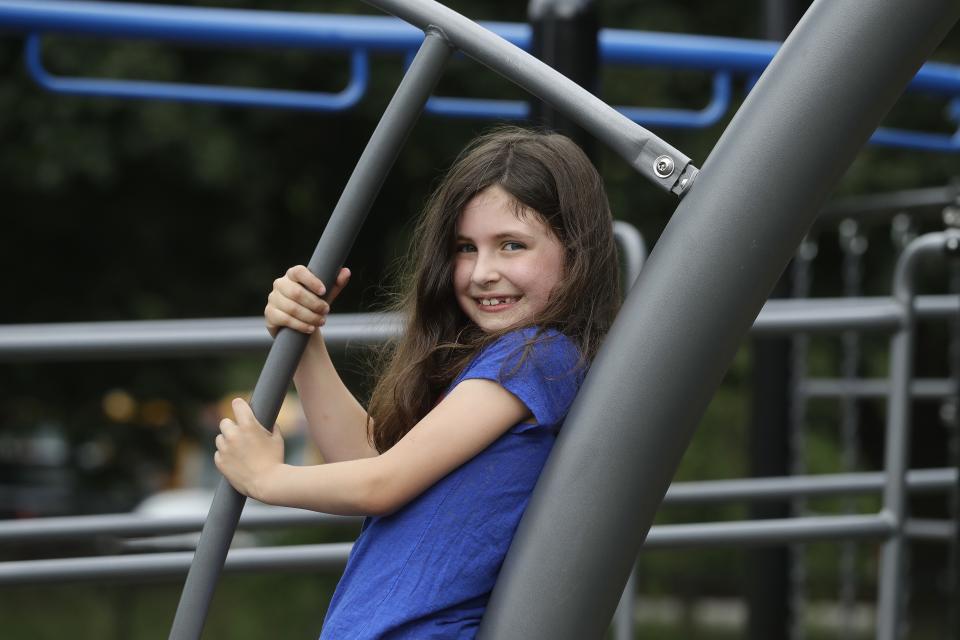 Sophia Garabedian, 6, of Sudbury, Mass., who contracted Eastern Equine Encephalitis in 2019, stands for a photograph on a playground, Wednesday, July 8, 2020, in Sudbury. As the coronavirus pandemic subsides for now in the hard hit Northeast, public health officials in the region are bracing for another mysterious virus: Eastern Equine Encephalitis, or EEE, a rare but severe mosquito-borne virus. (AP Photo/Steven Senne)