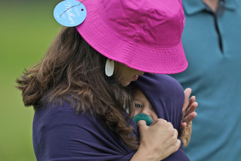 Aszia Pearson holds her daughter Madoc Person during the final round of the Byron Nelson golf tournament in McKinney, Texas, Sunday, May 14, 2023. (AP Photo/LM Otero)