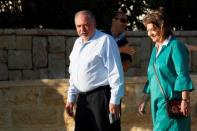 Avigdor Lieberman, leader of Yisrael Beitenu party, walks with his wife Ella as they arrive to cast their ballots in Israel's parliamentary election, at a polling station in the Israeli settlement of Nokdim in the occupied West Bank