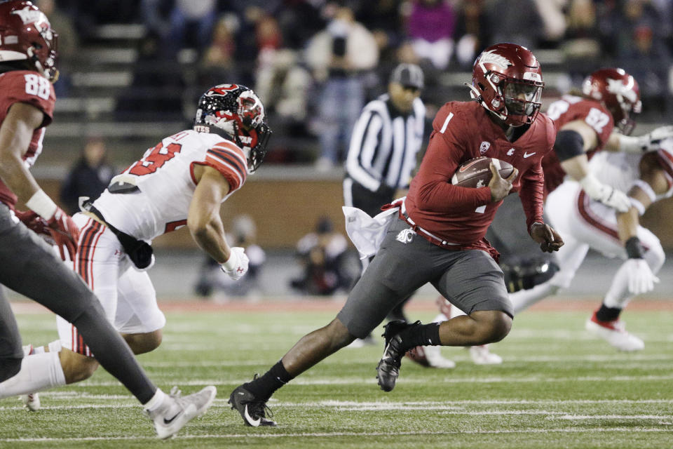 Washington State quarterback Cameron Ward, right, carries the ball while pressured by Utah safety Sione Vaki during the first half of an NCAA college football game, Thursday, Oct. 27, 2022, in Pullman, Wash. (AP Photo/Young Kwak)