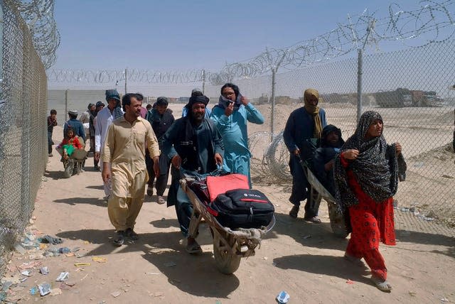 Afghan families enter Pakistan through a border crossing point in Chaman 