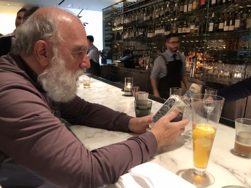 A customer at the Moderns looks at the Ming River baijiu bottle. (Krystal Hu/Yahoo Finance)