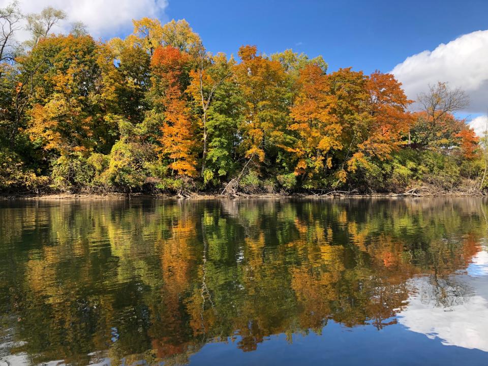 Fall colors reflect in the St. Joseph River in South Bend, seen from a kayak Oct. 16, 2022.