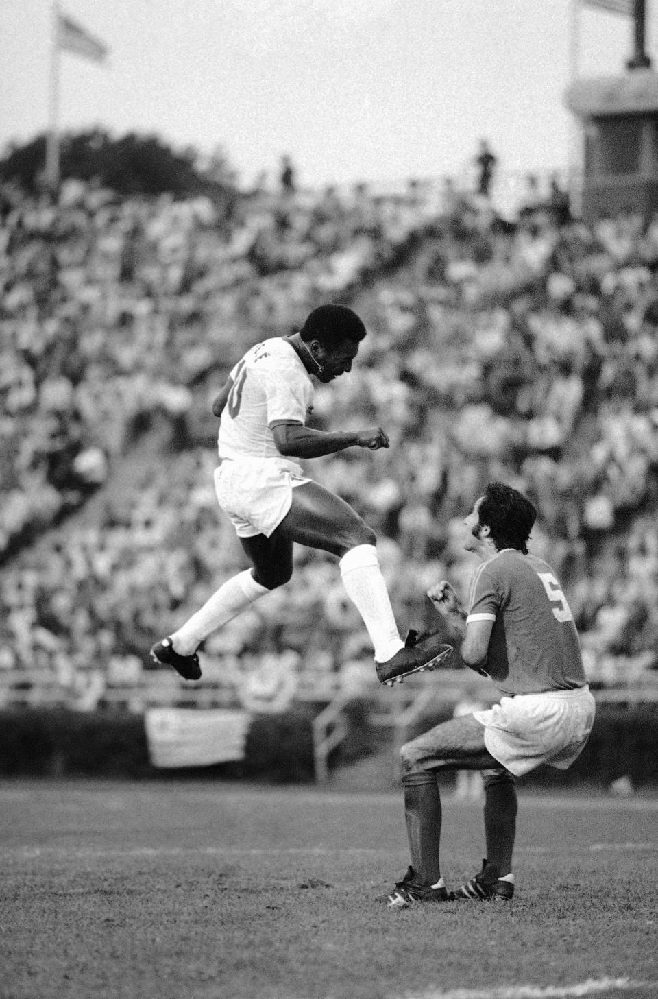 FILE - Pele reacts after heading the ball during a soccer match between the Cosmos and the Toronto Metro-Croatia in New York's Downing Stadium, June 19, 1975. Pelé, the Brazilian king of soccer who won a record three World Cups and became one of the most commanding sports figures of the last century, died in Sao Paulo on Thursday, Dec. 29, 2022. He was 82. (AP Photo/ Richard Drew, File)